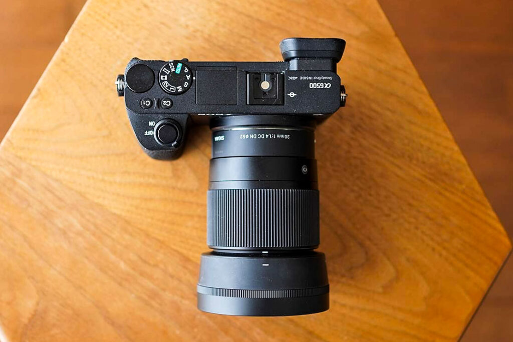 Showing the size of the Sigma 30mm f/1.4 DC DN lens mounted on a Sony a6500